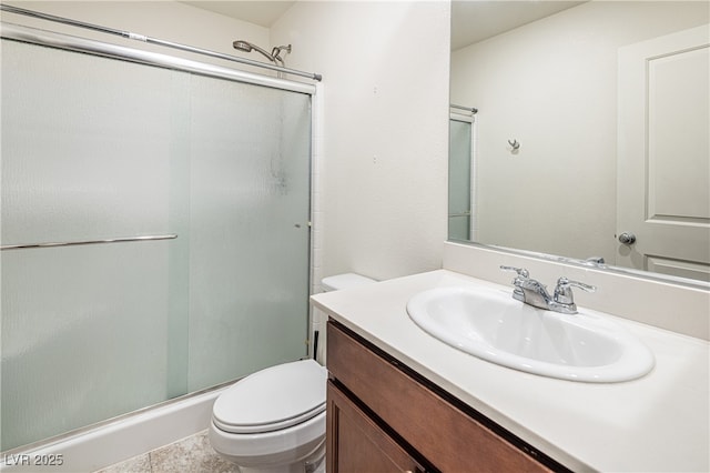 bathroom featuring toilet, a shower with door, and vanity