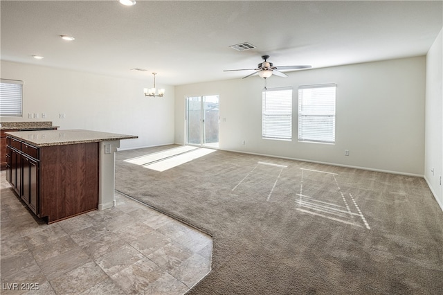 unfurnished living room featuring ceiling fan with notable chandelier and light colored carpet