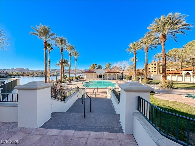 view of pool with a water and mountain view and a patio