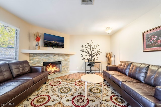 living room featuring hardwood / wood-style floors and a stone fireplace