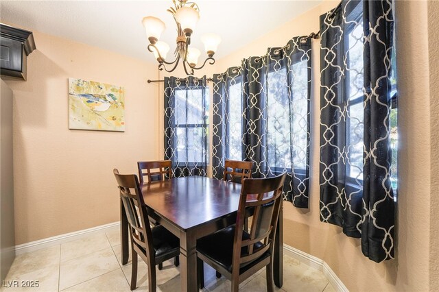 dining room with a wealth of natural light, tile patterned floors, and a chandelier