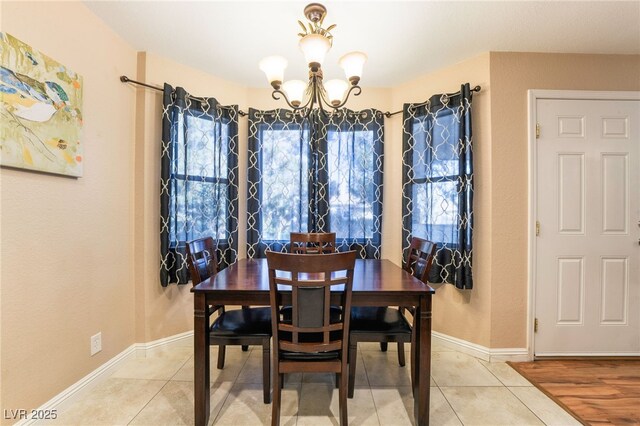 tiled dining space featuring a chandelier