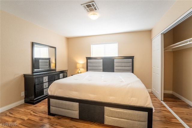 bedroom featuring multiple windows, a closet, and hardwood / wood-style floors