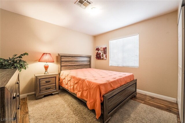 bedroom with dark hardwood / wood-style flooring