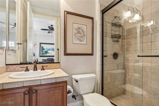 bathroom with toilet, a shower with door, vanity, and ceiling fan