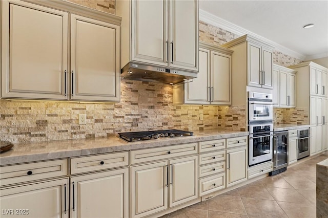 kitchen with ornamental molding, decorative backsplash, appliances with stainless steel finishes, and cream cabinetry