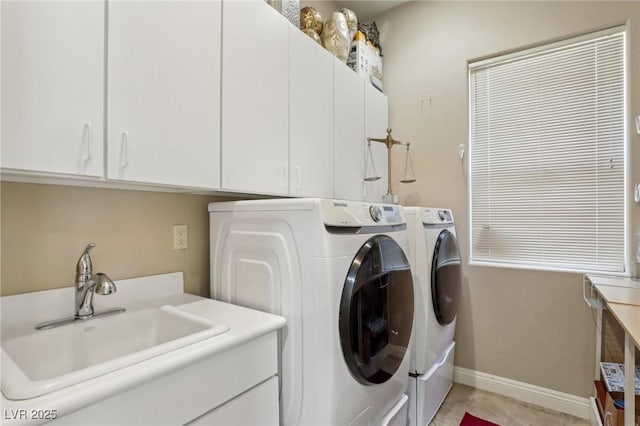 laundry area featuring independent washer and dryer, cabinets, and sink