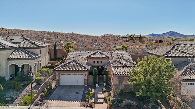 mediterranean / spanish house featuring a garage and a mountain view