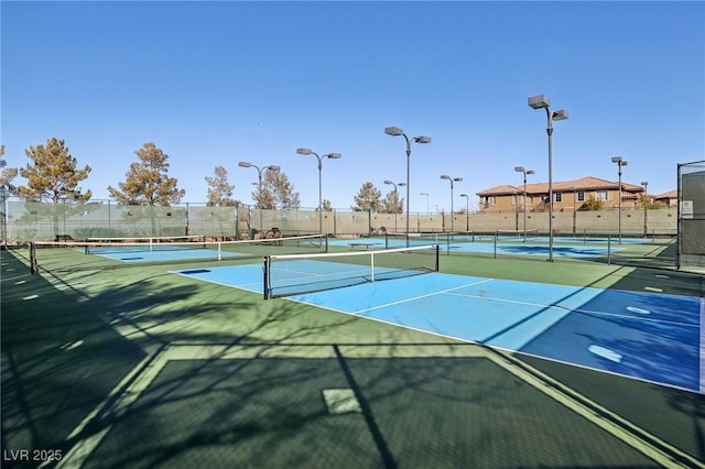 view of tennis court with basketball hoop