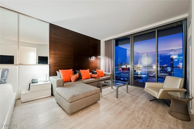 living room with light wood-type flooring and a wall of windows