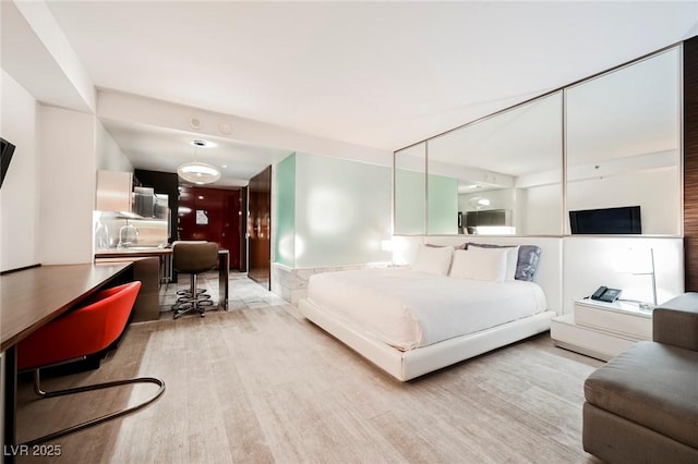 bedroom with light hardwood / wood-style floors and sink