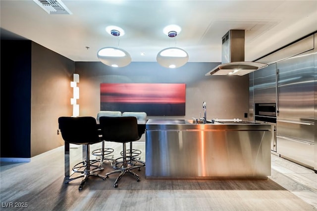 kitchen with island range hood and stainless steel counters