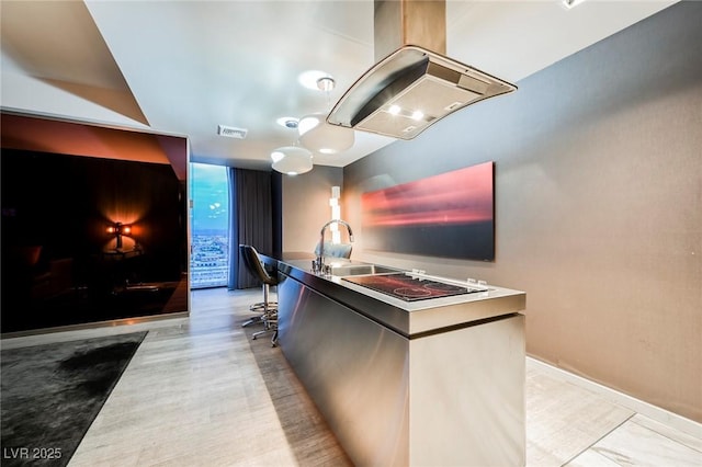 kitchen featuring black electric cooktop, island exhaust hood, and sink