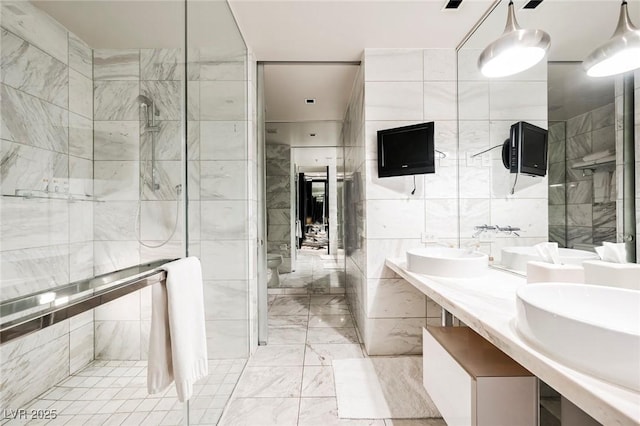 bathroom with toilet, a shower, vanity, and tile walls