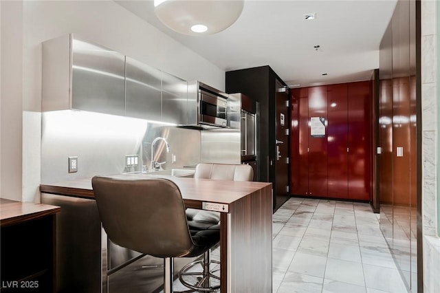 kitchen with kitchen peninsula, a breakfast bar, and sink