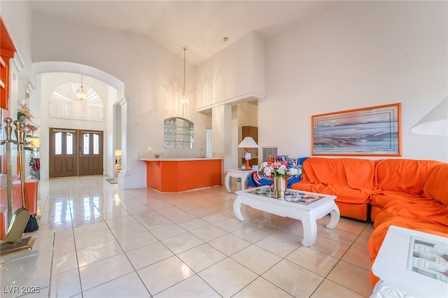 living room with a notable chandelier, high vaulted ceiling, and light tile patterned floors