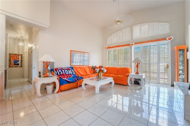 tiled living room with a notable chandelier and a high ceiling