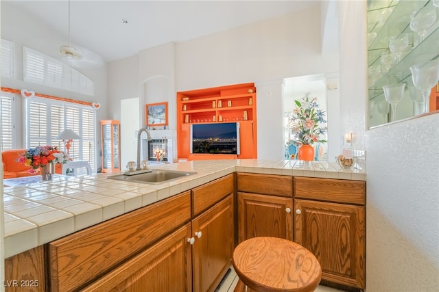 kitchen with sink, kitchen peninsula, and tile counters