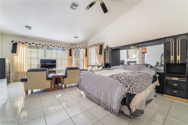 bedroom with ceiling fan, lofted ceiling, and light tile patterned floors