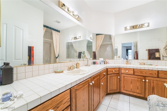 bathroom with a shower, vanity, and tile patterned floors