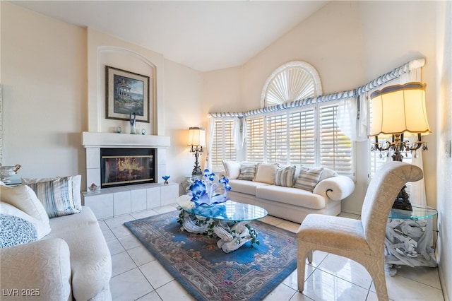 living room featuring lofted ceiling, a tile fireplace, and light tile patterned floors