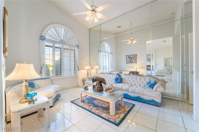 living room featuring light tile patterned floors, high vaulted ceiling, ceiling fan, and a wealth of natural light