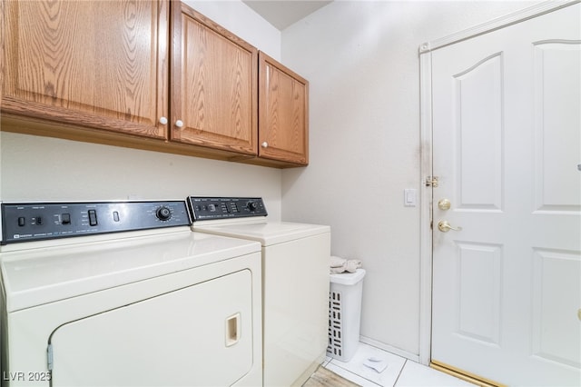 washroom with washer and dryer and cabinets