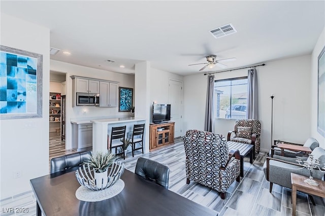 living room with ceiling fan and light hardwood / wood-style floors