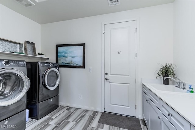 laundry room with sink, cabinets, and separate washer and dryer