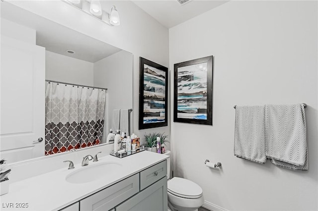 bathroom featuring toilet, a shower with shower curtain, and vanity