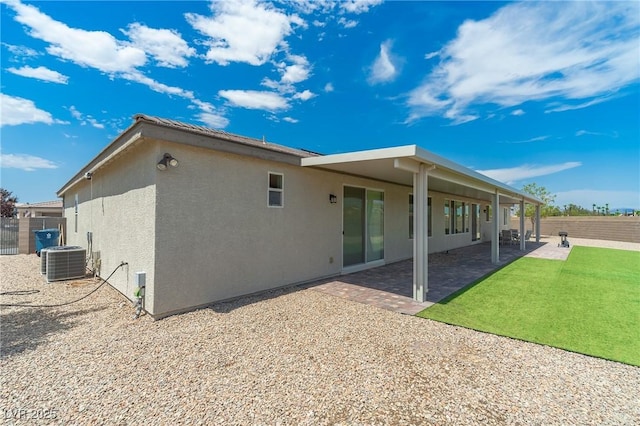 back of property with a patio area, central AC unit, and a lawn