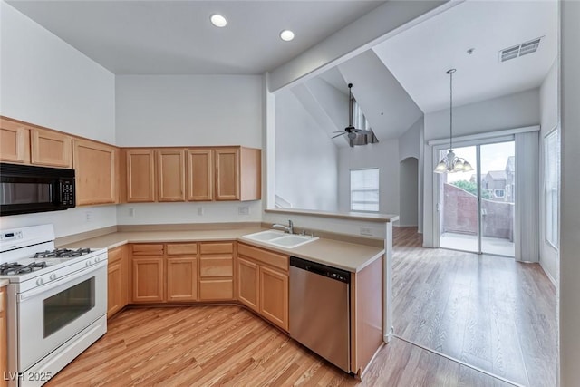 kitchen featuring sink, white gas range oven, kitchen peninsula, stainless steel dishwasher, and hanging light fixtures