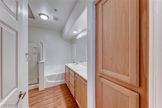 bathroom with shower with separate bathtub, vanity, a textured ceiling, and hardwood / wood-style floors