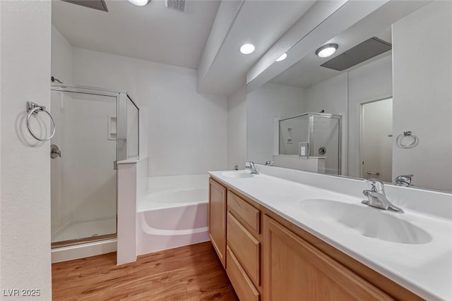 bathroom with vanity, hardwood / wood-style floors, and plus walk in shower