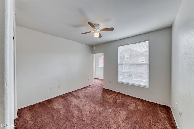 carpeted spare room with ceiling fan