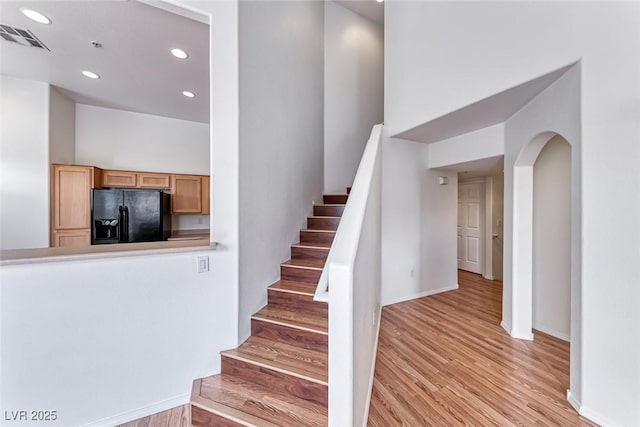 stairway featuring a high ceiling and hardwood / wood-style flooring