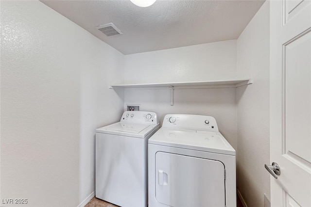 laundry room featuring a textured ceiling and washing machine and clothes dryer