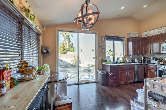 kitchen featuring vaulted ceiling, a wealth of natural light, appliances with stainless steel finishes, and decorative backsplash