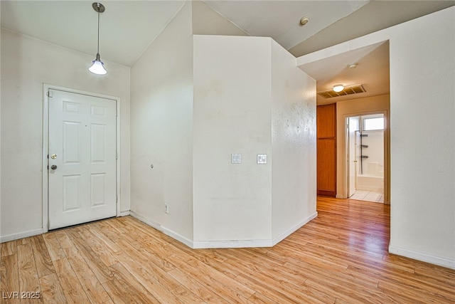 entrance foyer with vaulted ceiling and light hardwood / wood-style flooring