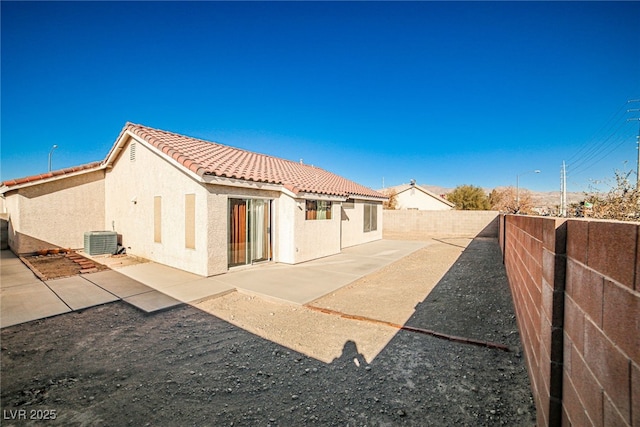 rear view of property with central air condition unit and a patio