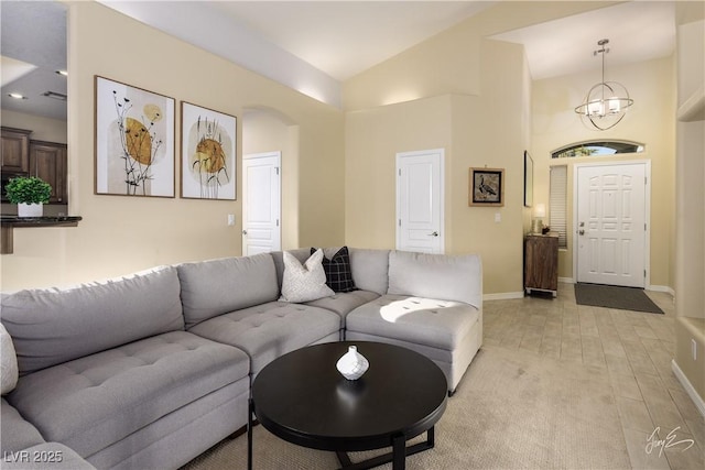 living room featuring a notable chandelier and lofted ceiling