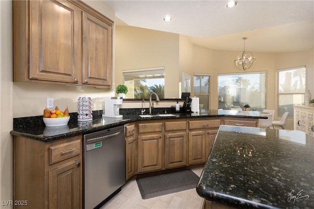 kitchen featuring vaulted ceiling, a chandelier, dark stone counters, sink, and stainless steel dishwasher