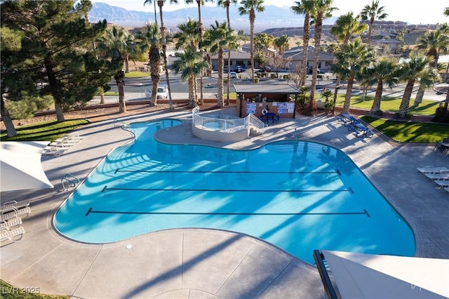 view of swimming pool featuring a patio area, a bar, and a mountain view