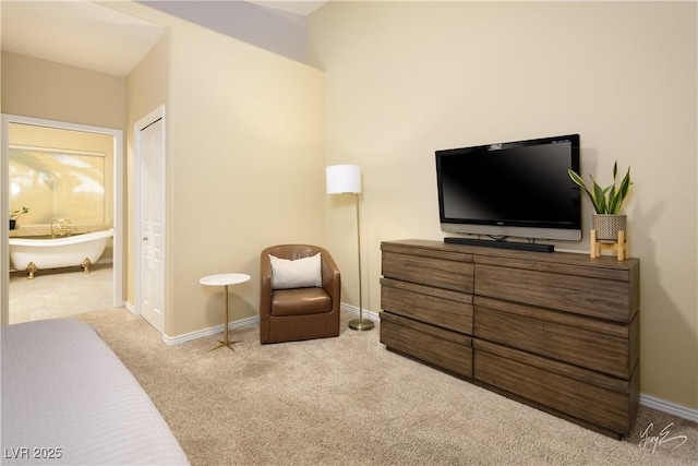 bedroom with ensuite bath and light colored carpet