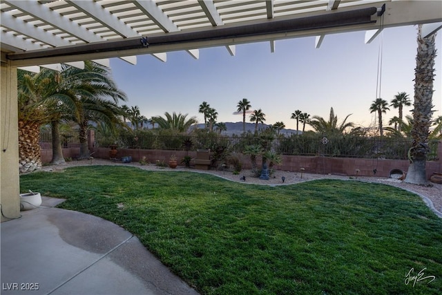 yard at dusk featuring a pergola