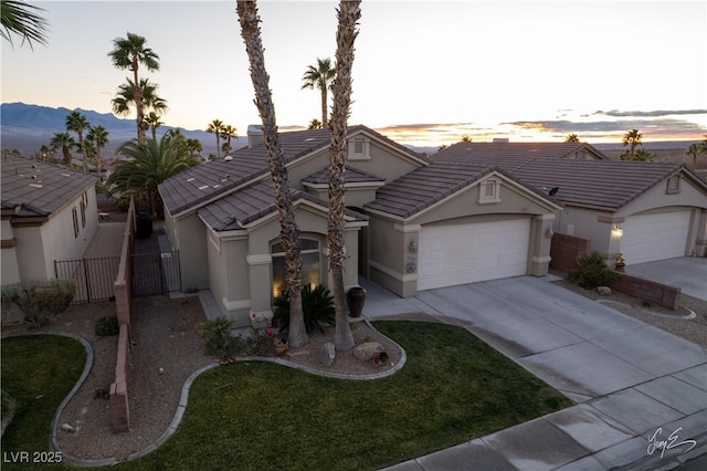 ranch-style house featuring a garage and a lawn