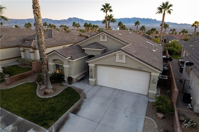 view of front of home with a garage and a mountain view