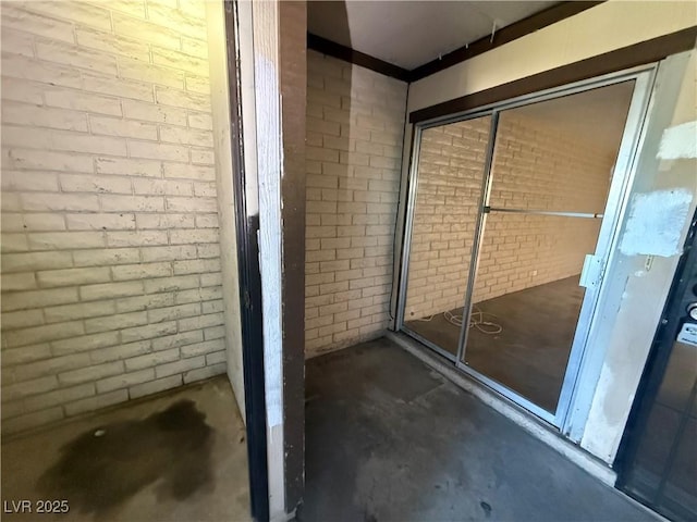 bathroom with brick wall and concrete flooring