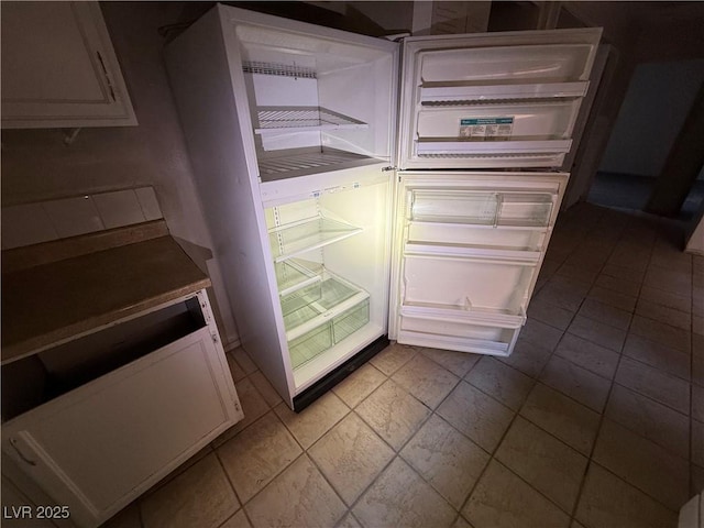 kitchen featuring white cabinets and refrigerator