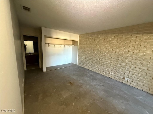 interior space featuring brick wall, a textured ceiling, and sink